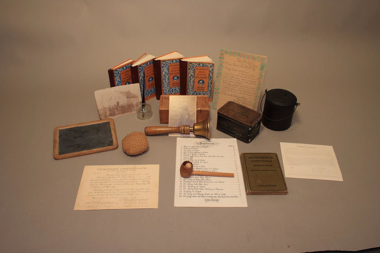 The trunk includes a chalk slate, historical papers, a bell, books and photographs.