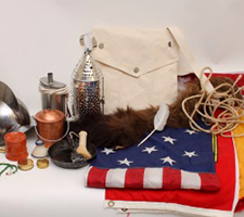 A canvas bag, flags, and small items from traveling trunks.