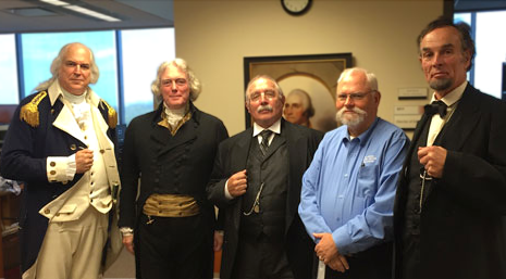A group of presidential living history reenactors standing with a volunteer.