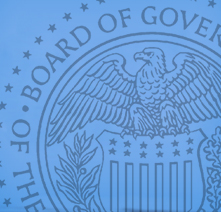 Magnification of the Federal Reserve Seal featuring an eagle sitting atop a shield 