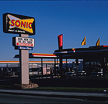 An evening photograph of Sonic Drive-In with illuminated signage 