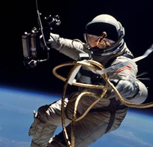 Astronaut in a space suit and helmet with Earth visible in the distant background