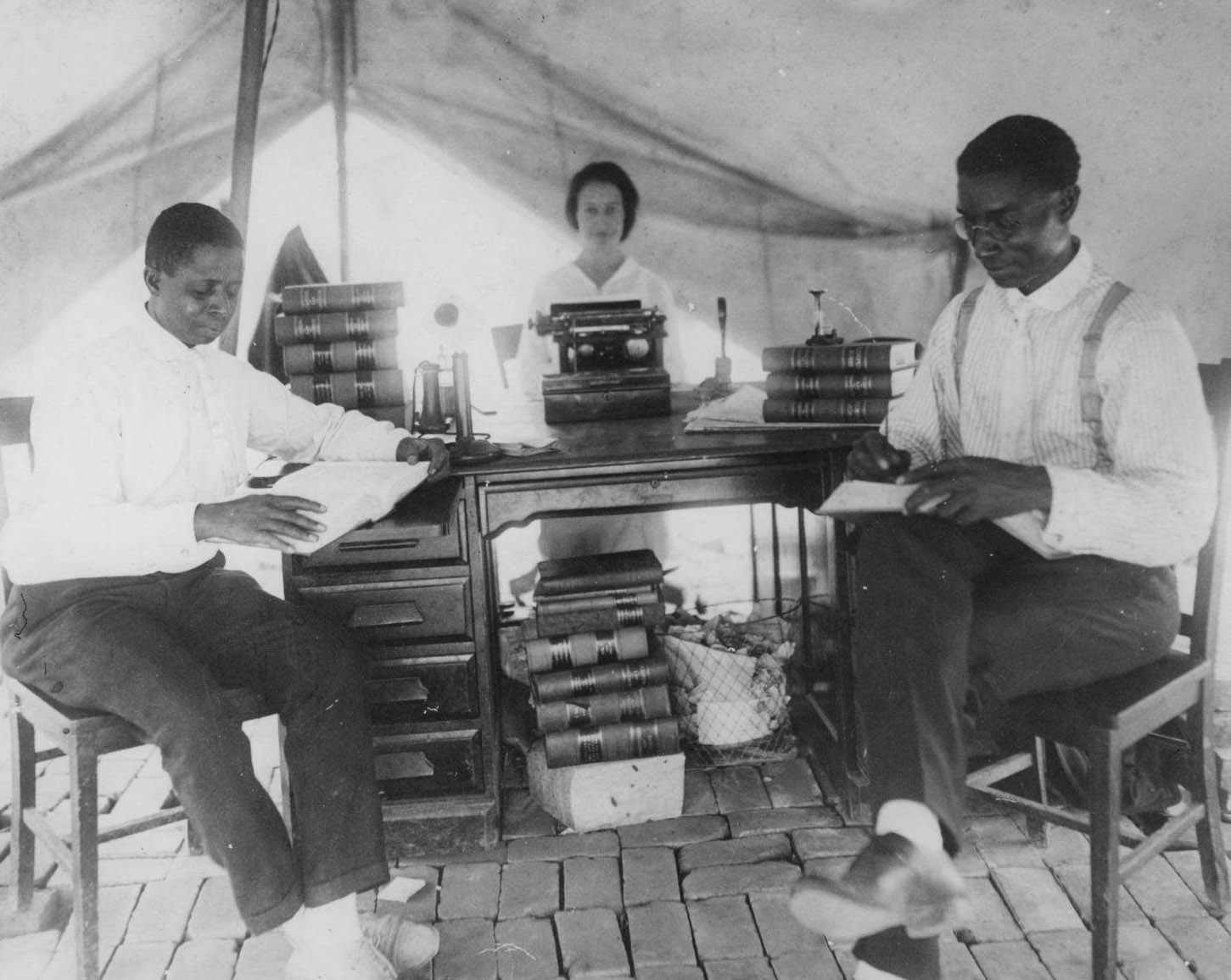 Après le massacre racial de Tulsa en 1921, l'avocat B.C. Franklin (à droite) a installé son cabinet d'avocats dans une tente. Sur la gauche se trouve I. H. Spears, l'associé juridique de Franklin. Ces hommes ont œuvré pour empêcher la dépossession des habitants de Greenwood.