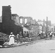 Survivors standing in the burnt remained of structures following the Tulsa Race Massacre