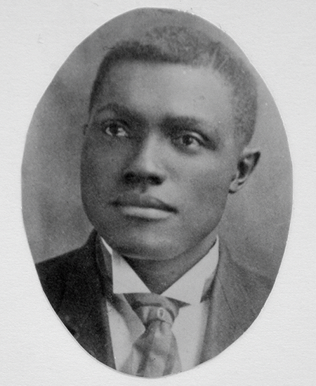 A portrait of a Black man in a suit.