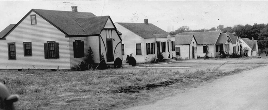 A black and white photo of a row of middle-class houses. 
