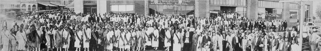 A panoramic photo of around three hundred Black people. Most of the women wear sashes. 