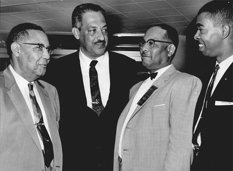 A group of four Black men wearing suits. 