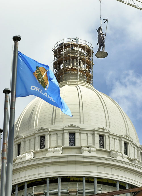 A crane lowers a The Guardian sculpture on to the dome.