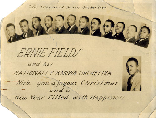 Small portraits of orchestra members is under the hand-written text 'The Cream of Dance Orchestras.' Larger writing reads, 'Ernie Fields and his Nationally Known Orchestra wish you a joyous Christmas and a New Year Filled with Happiness,' with a larger portrait of Fields.