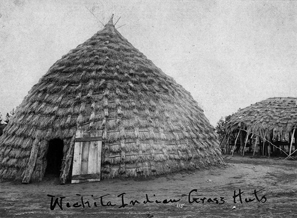 Historic photograph of a cone-shaped Wichita grass house. The grass is laid in an overlapping pattern.