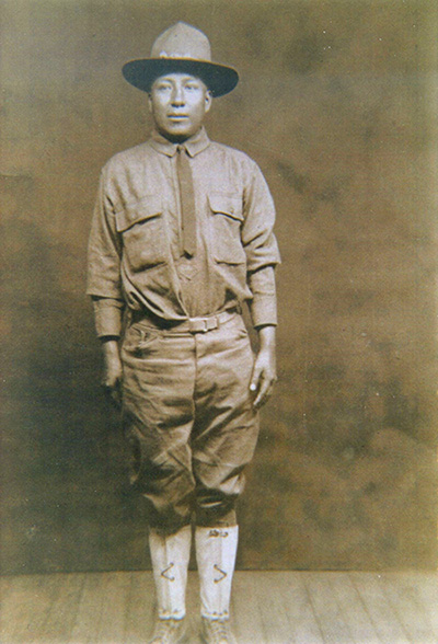 A posed sepia portrait of Tobias Frazier in a World War I era uniform. He is standing at attention. 