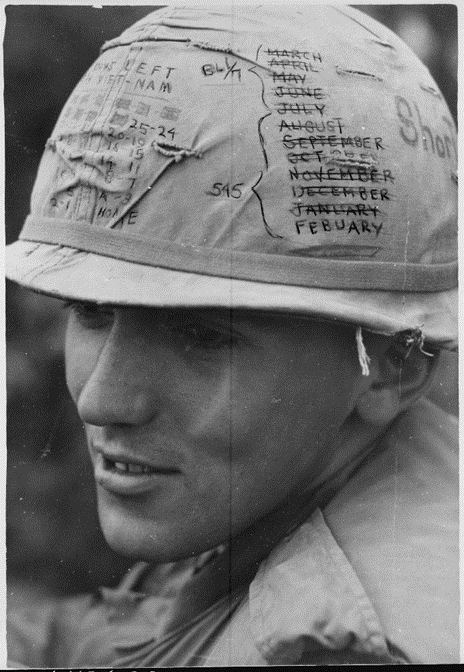 A young soldier with a list of months crossed out on his helmet