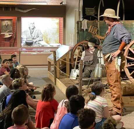 Students watch a historical interpreter at The Chisholm